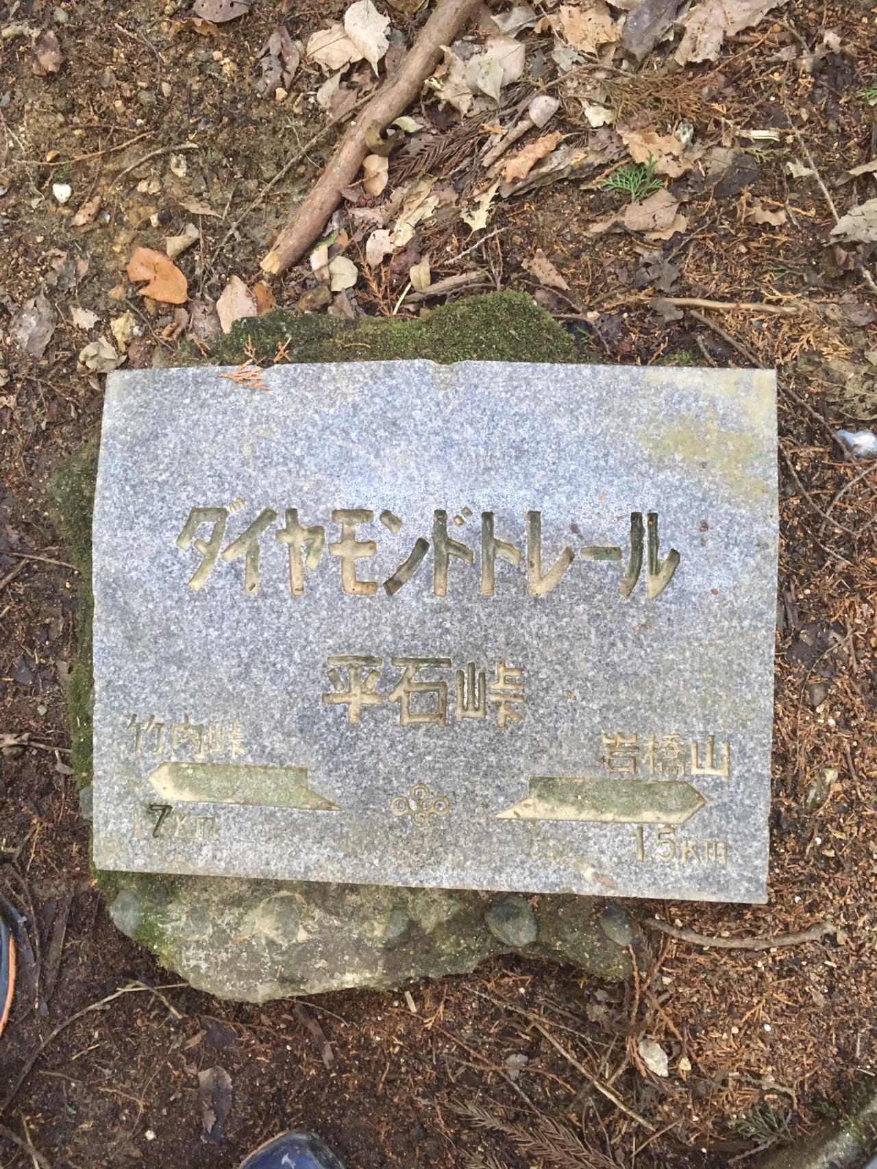 地面に据えられたダイヤモンドトレールの石標。「平石峠」「竹内峠1.7km」「岩橋山1.5km」と彫られている