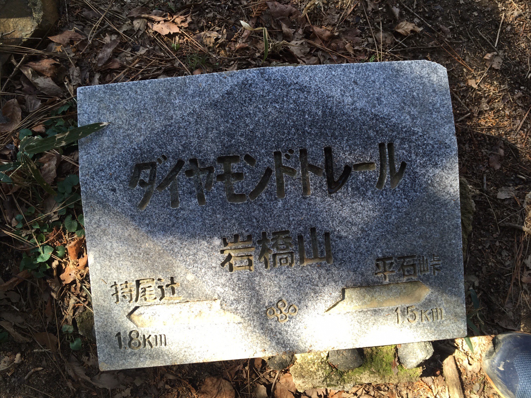 ダイヤモンドトレールの石標。「岩橋山」「持尾辻1.8km」「平石峠1.5km」と彫られている