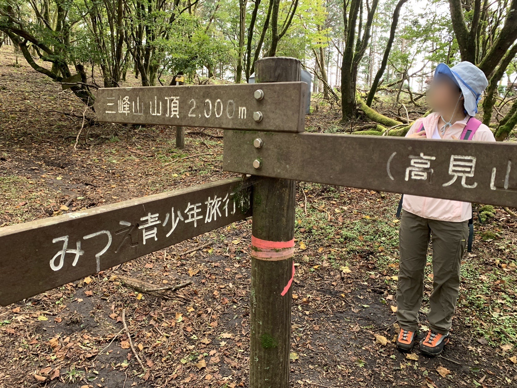 新道峠の木製道標。「三峰山 山頂 2,000m」「みつえ青少年旅行村」「高見山」と書かれている