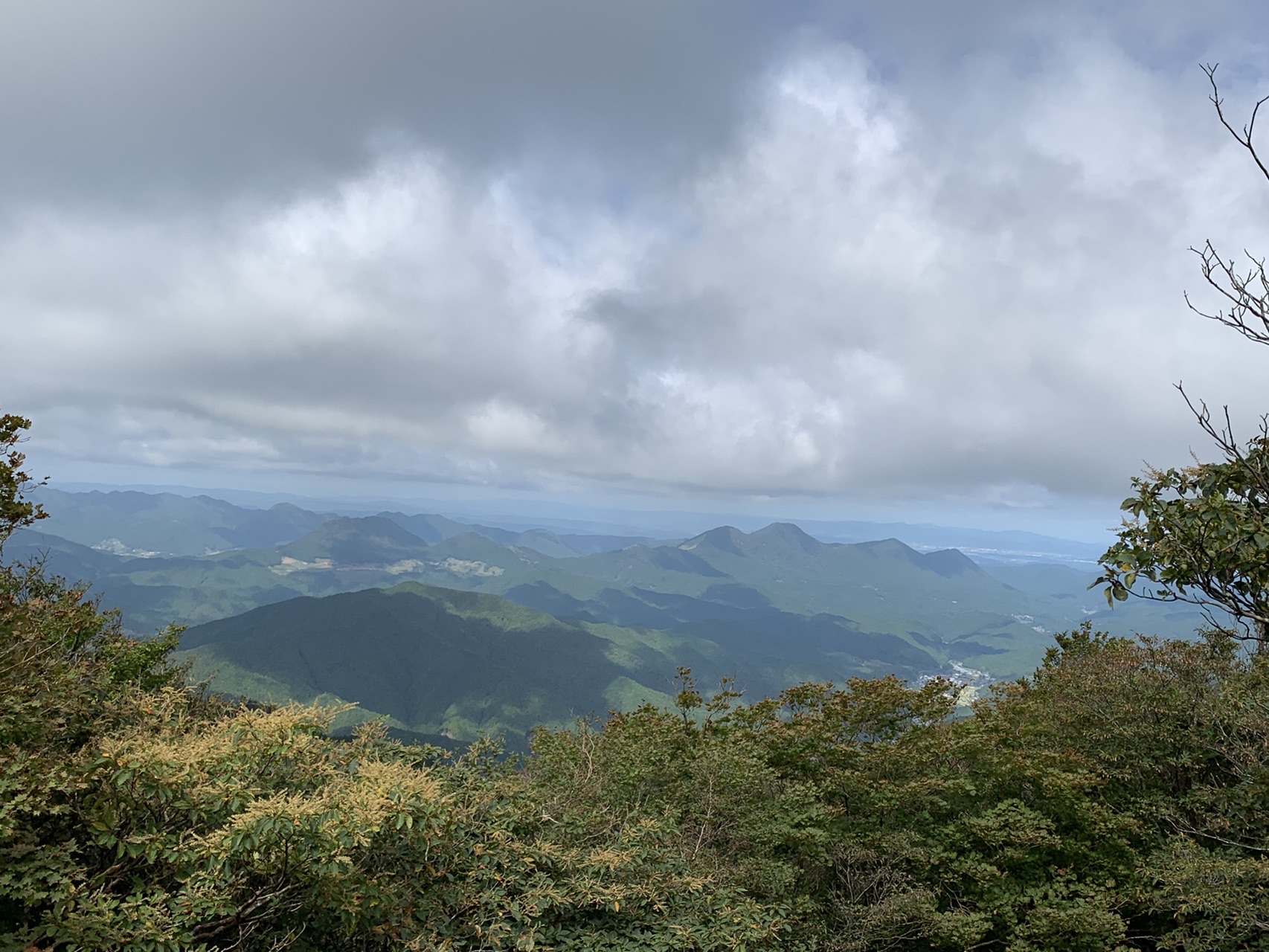 三峰山山頂から北側の展望。曇り空の下に幾重にも重なる山並み