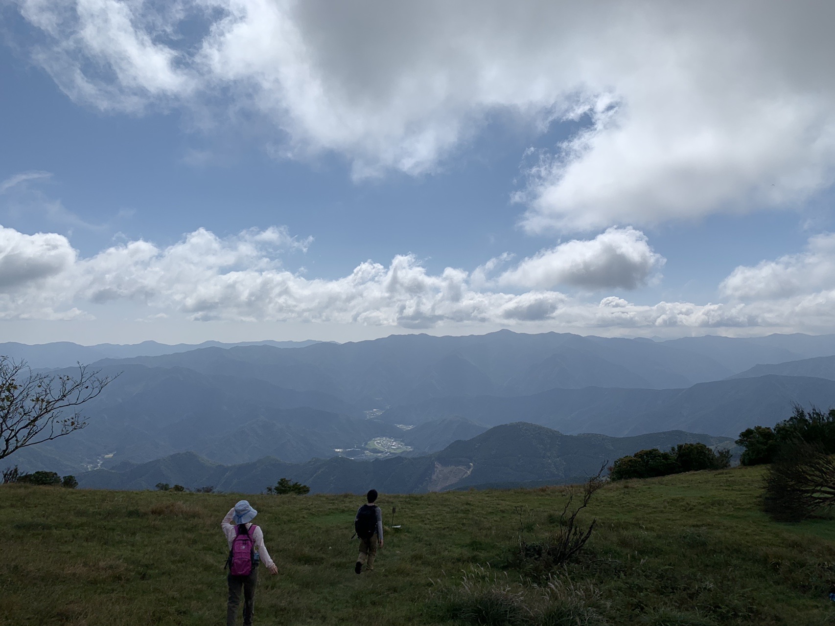 八丁平の草原の向こうに広がる山並みと雲の多い空