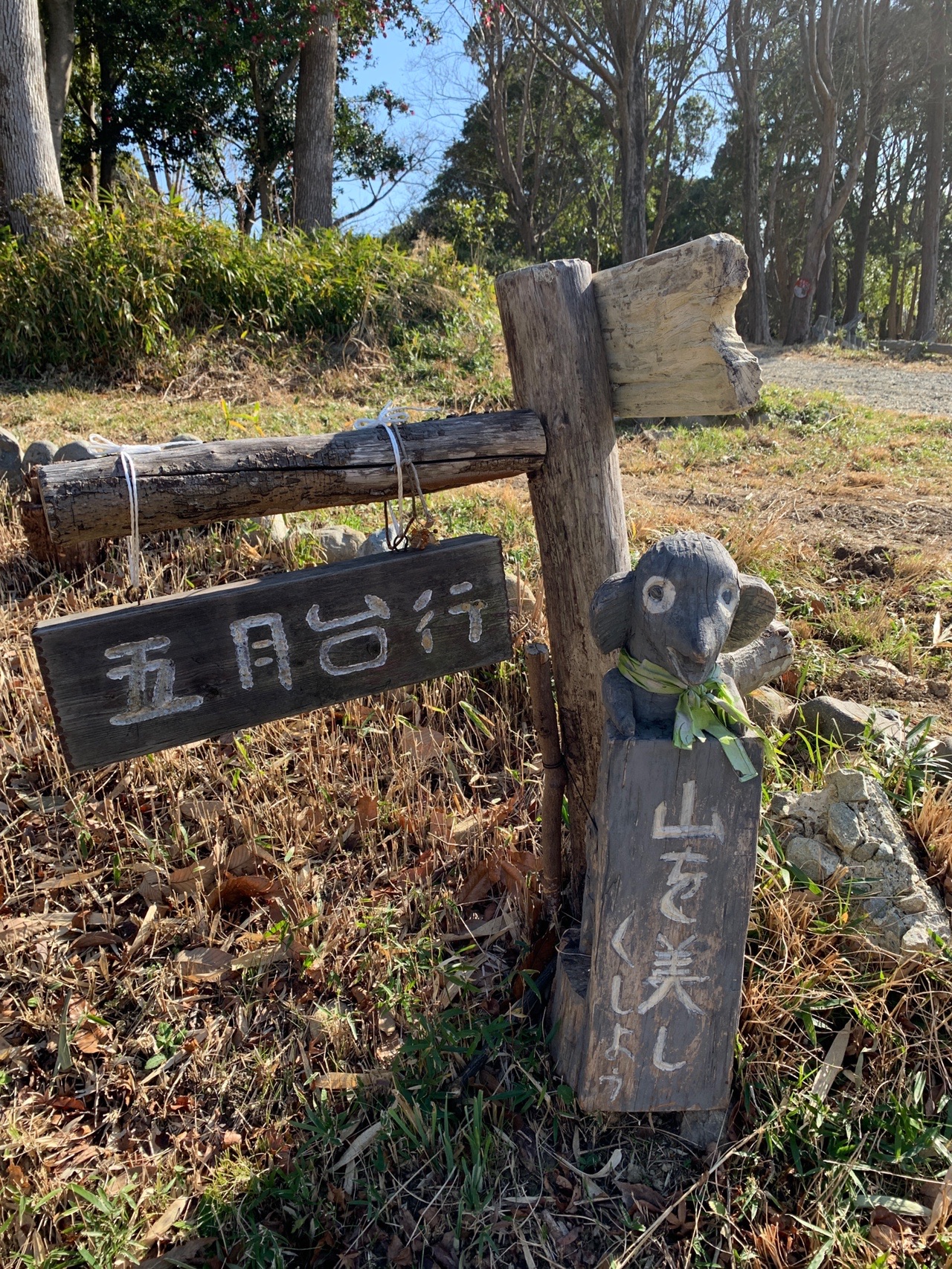 木の道標が2本立っている。「五月台行」と書かれた板と、縦書きの札が下がっている
