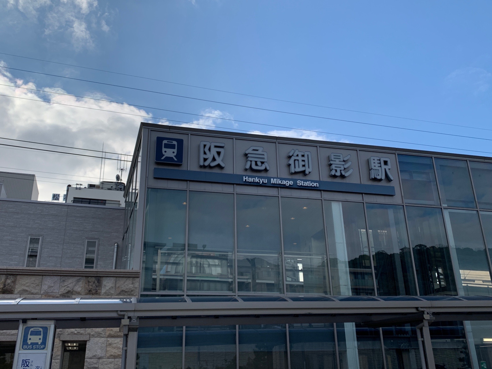 阪急御影駅の駅舎。ガラス張りの壁面に「阪急御影駅」の看板が付いている。青空が広がる