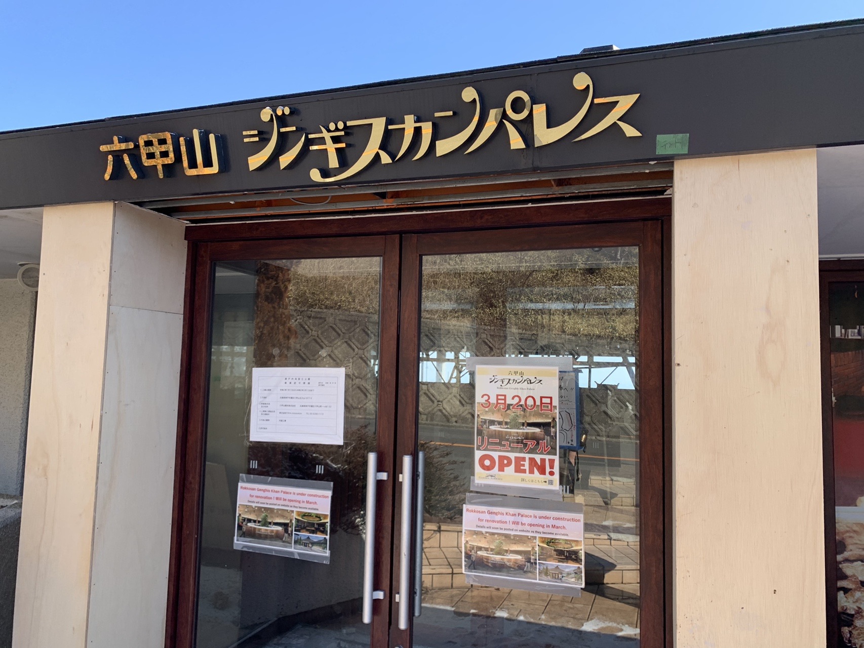 「六甲山ジンギスカンパレス」の看板が付いた建物の入口。ガラス戸に休業を知らせる貼り紙が貼られている