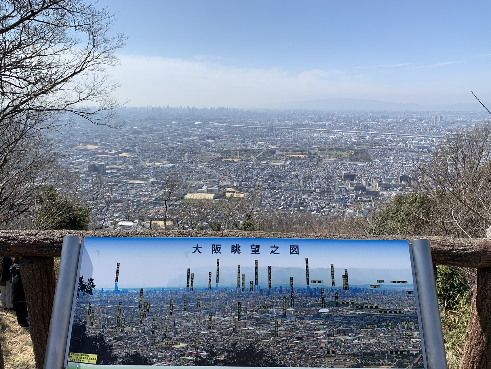 展望台の2階から見下ろす大阪平野。手前に案内板、遠くまで市街地が続いている
