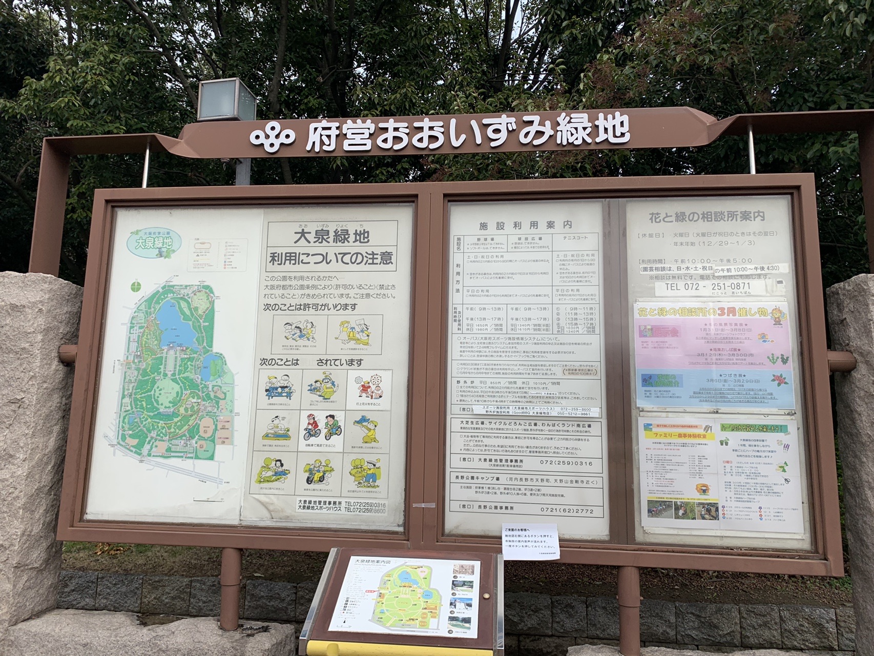 「府営おおいずみ緑地」と書かれた木枠の案内板。園内マップと利用案内が掲示されている