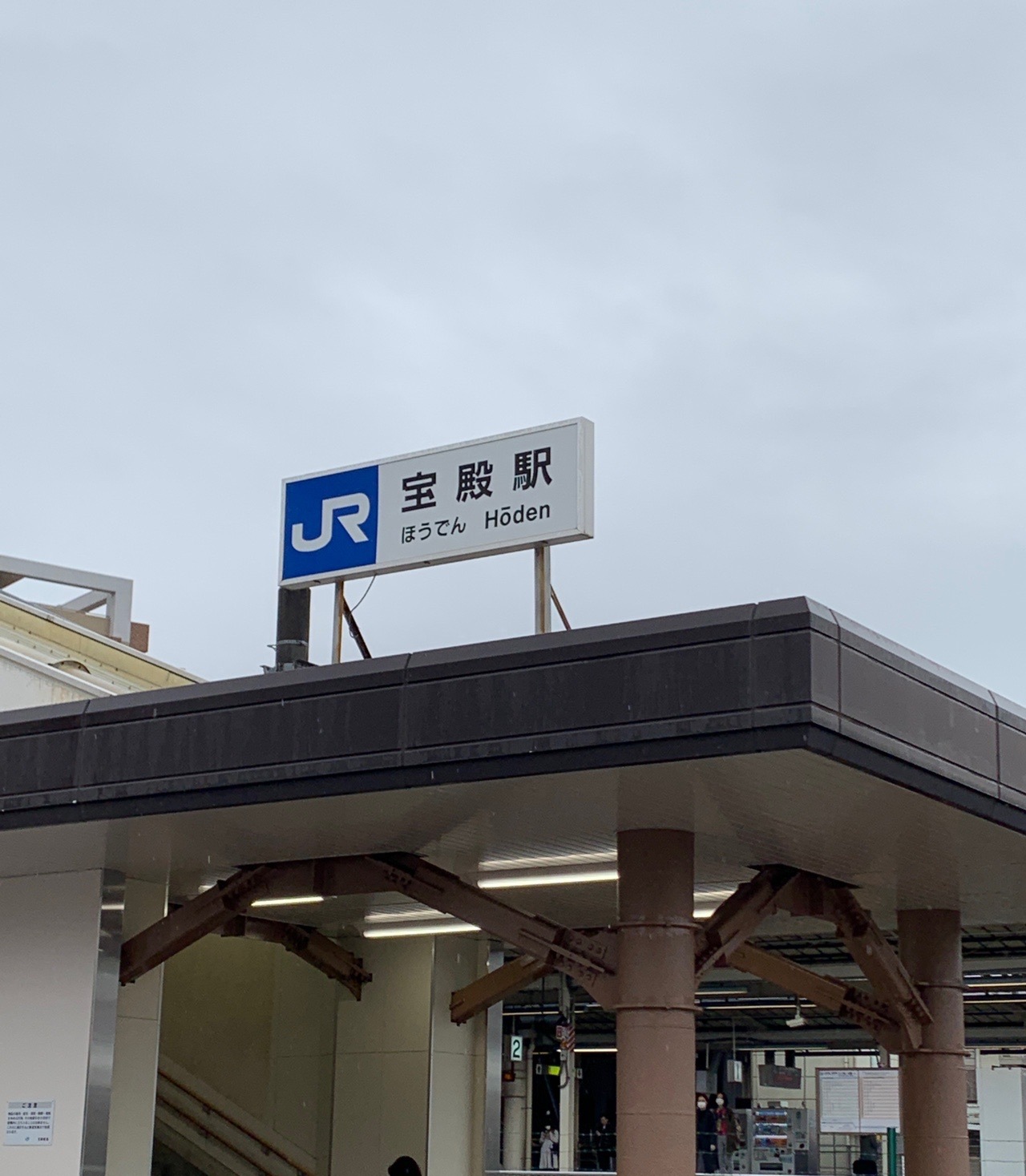 JR宝殿駅の駅舎。曇り空の下、駅名標が見えている
