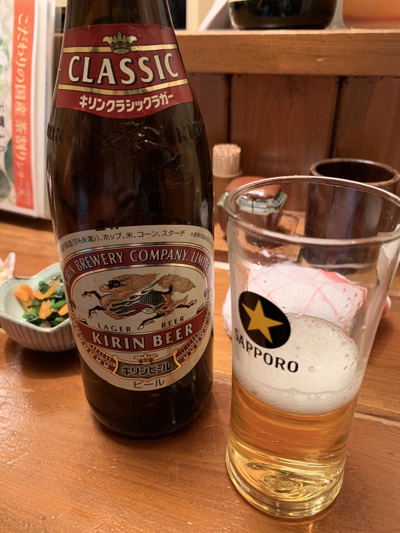 テーブルに置かれた瓶ビールとグラス。グラスには少し注がれている