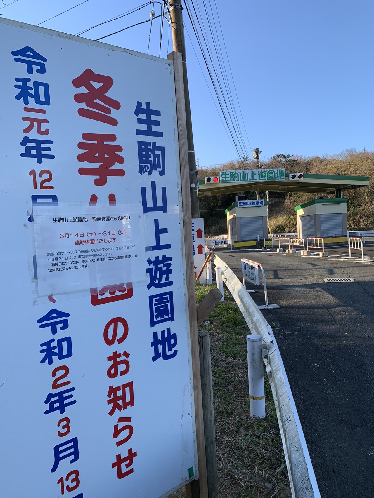 生駒山上遊園地の冬季休園の看板。その上に「臨時休園のお知らせ 3月14日(土)〜31日(火)」と書かれた紙が貼られている