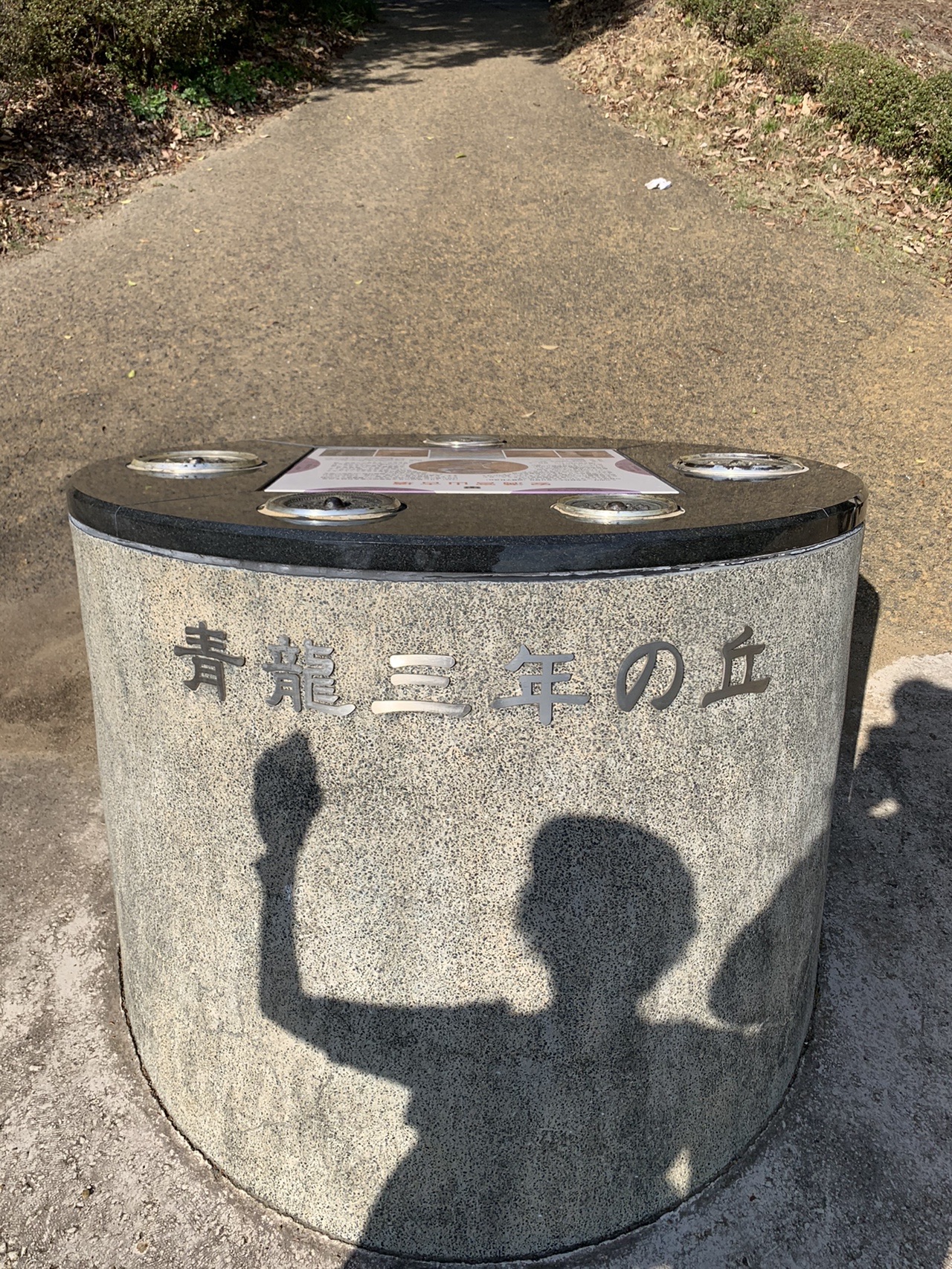円柱形の石に「青龍三年の丘」と刻まれている。上面に鏡を模した円い金属板が埋め込まれている
