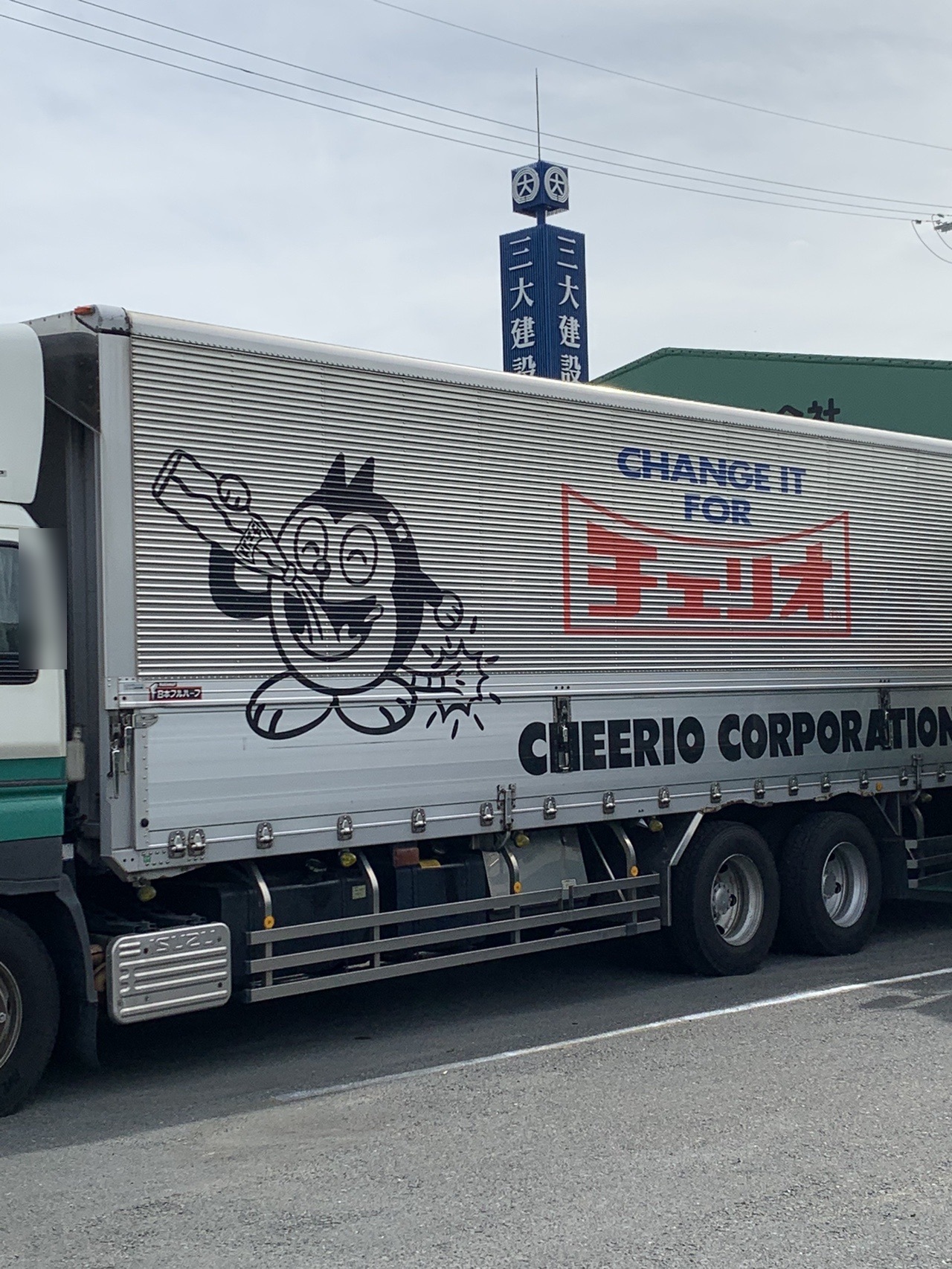 道路に停まった保冷トラック。荷台にチェリオの猫のキャラクターが大きく描かれている