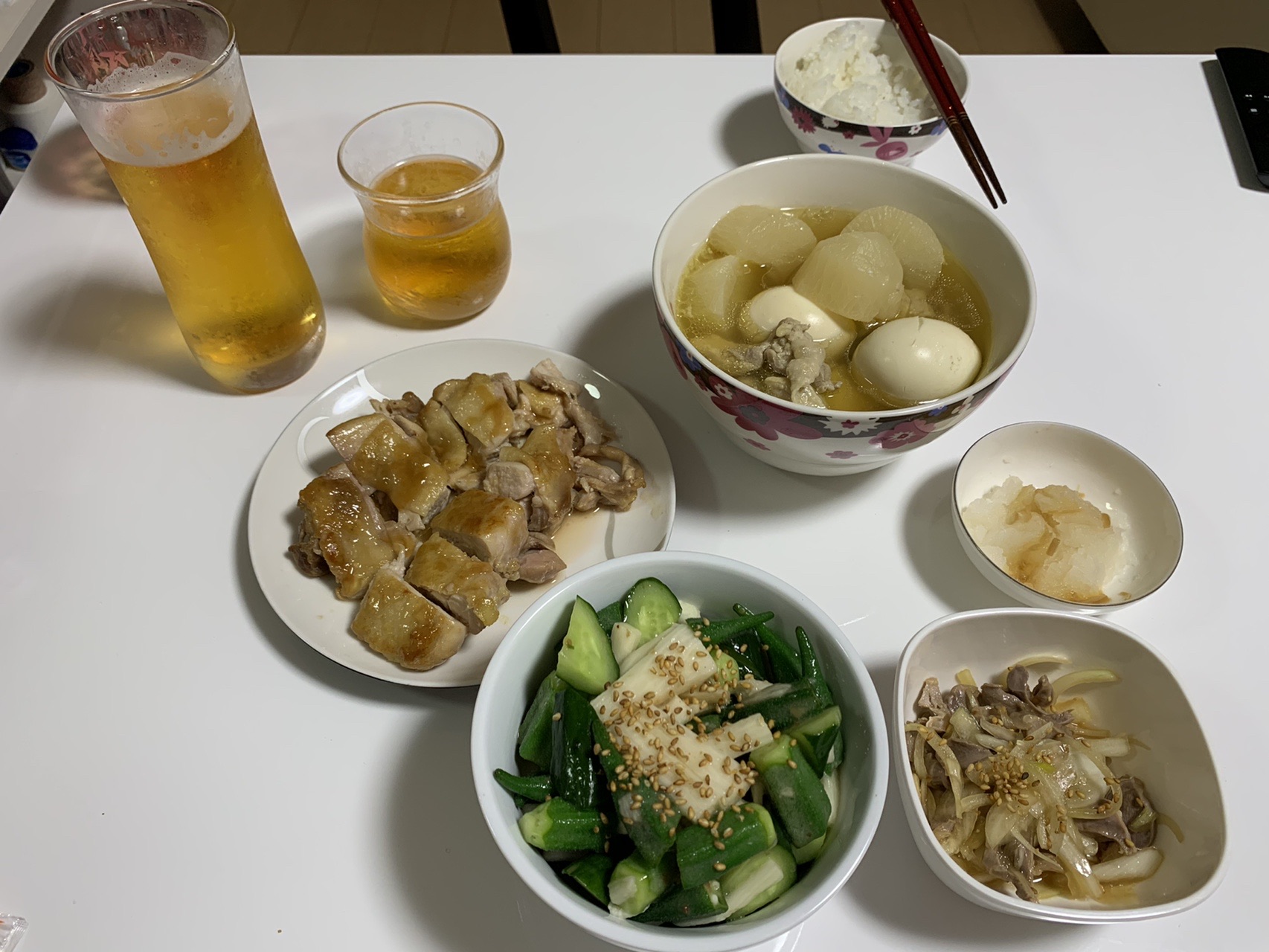 食卓に並んだ小鉢料理。きゅうりの和え物、里いも、きのこ、揚げ物、ごはん、飲み物