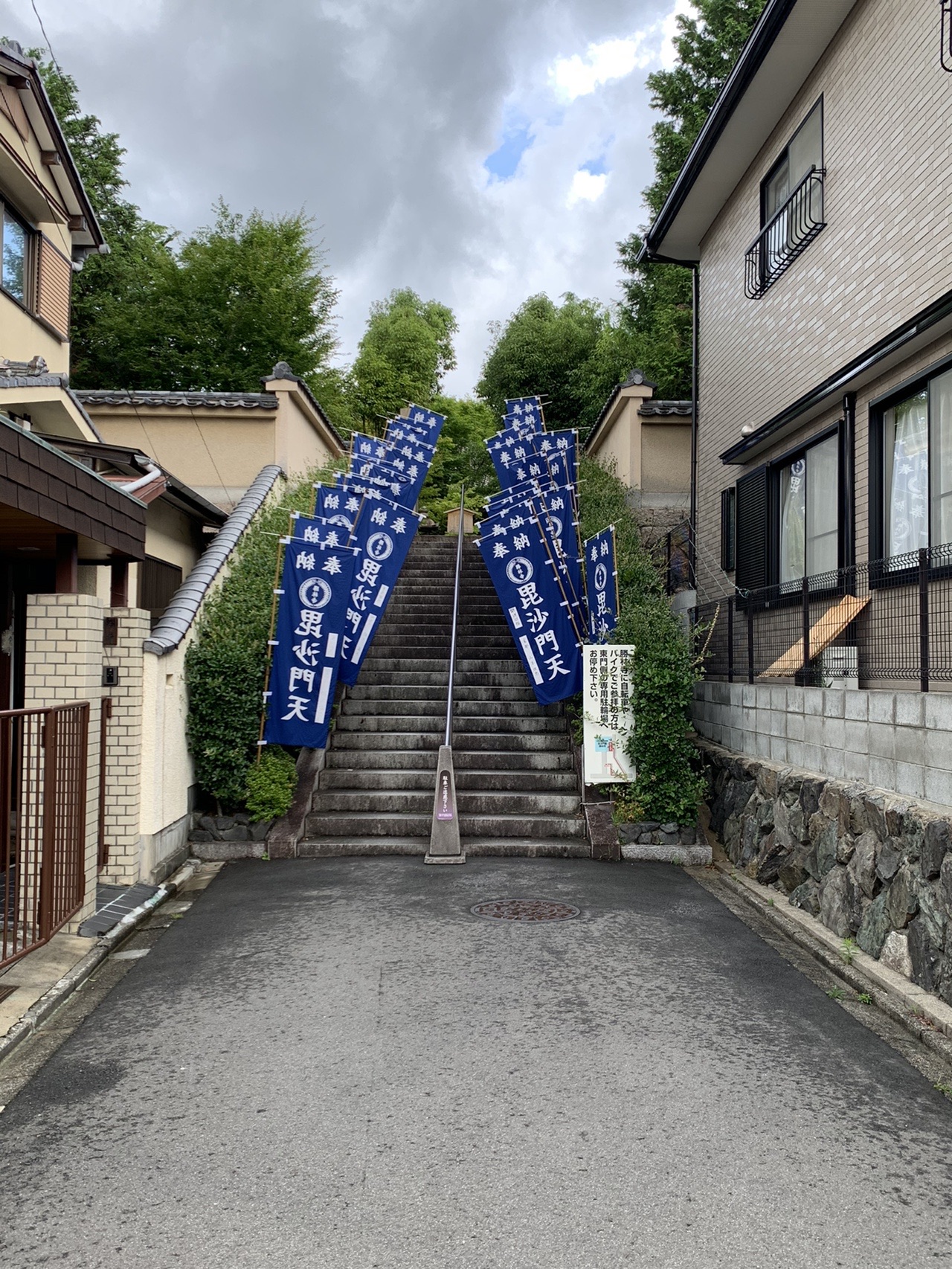 住宅の間の細い階段の両側に、青い幟が並んで立っている