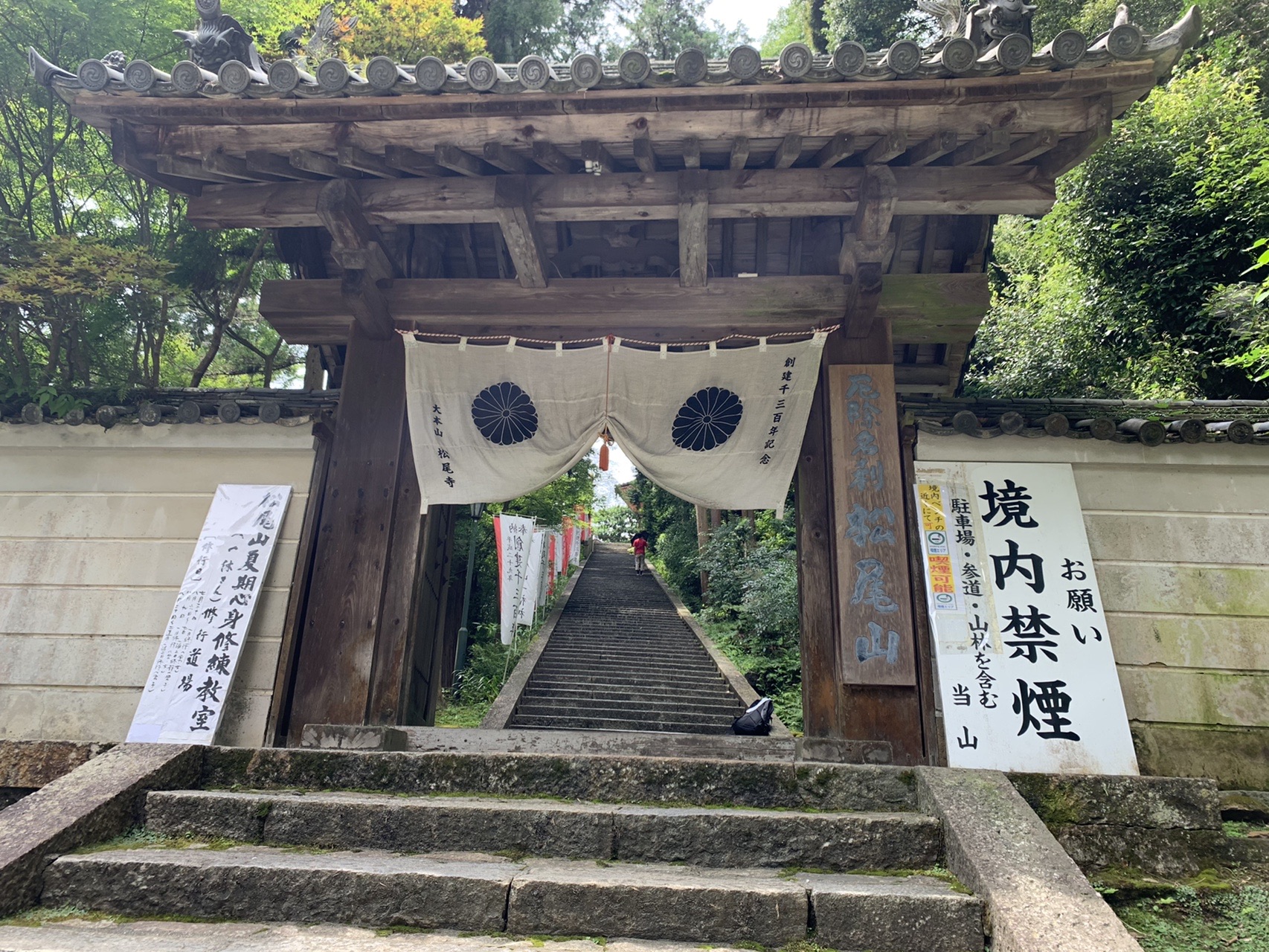松尾寺の山門と、その奥へ続く石段の参道。門には白い幕がかかっている