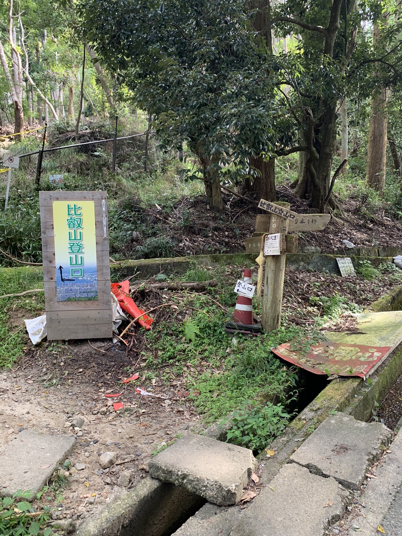 「比叡山登山口」と書かれた黄色い看板と、その奥の登山道