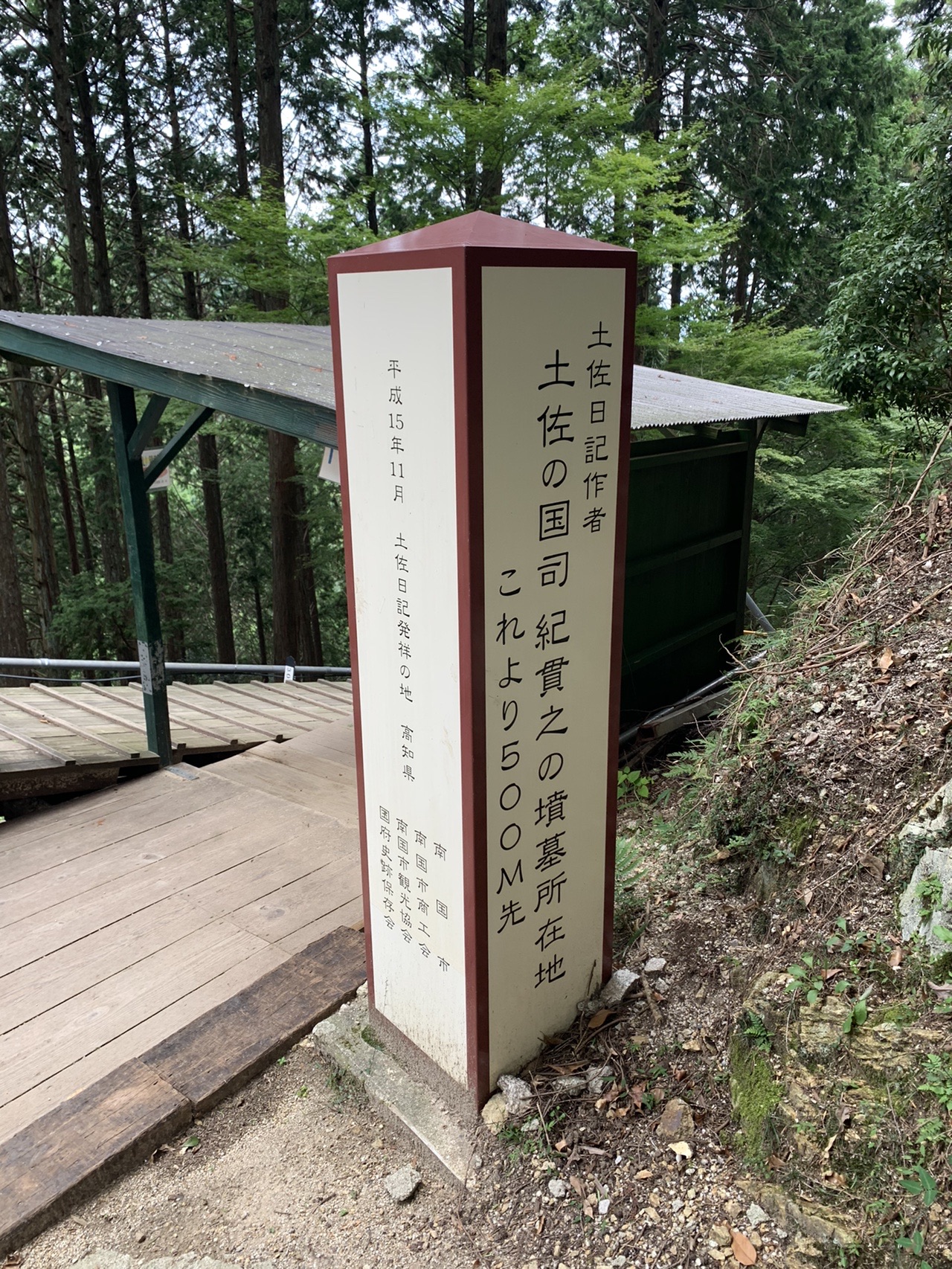 山道の脇に立つ「紀貫之」と書かれた白い案内標柱