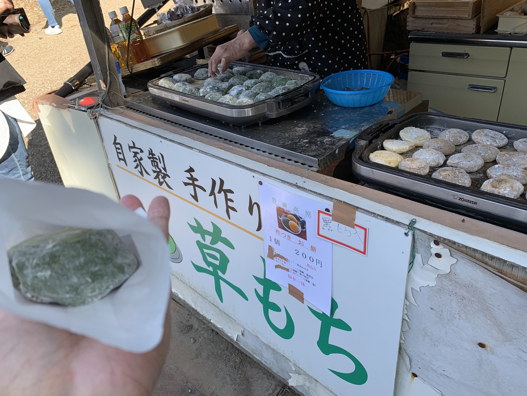 「自家製 手作り 草もち」の看板と、手に持った草もち