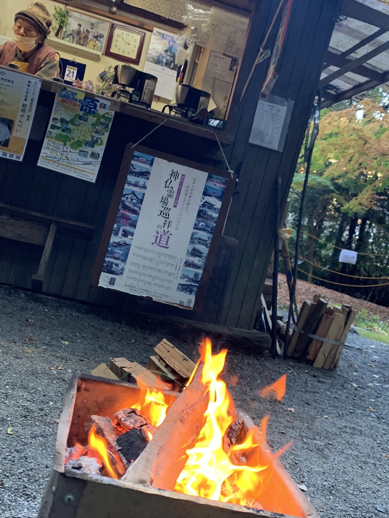 屋外の売店と、その前で燃えている焚き火