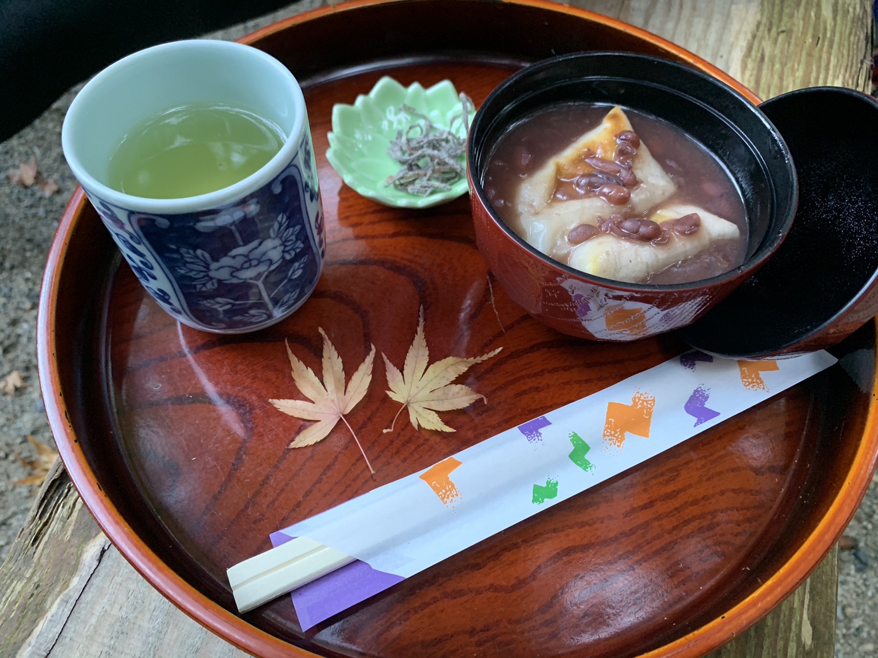 お盆にのったおしることお茶。盆には紅葉の飾りが添えられている