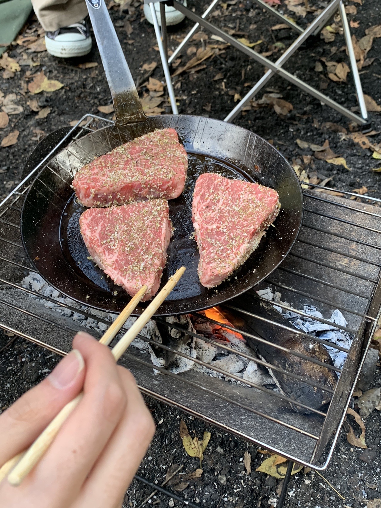 フライパンの上で焼かれている厚切りのステーキ肉