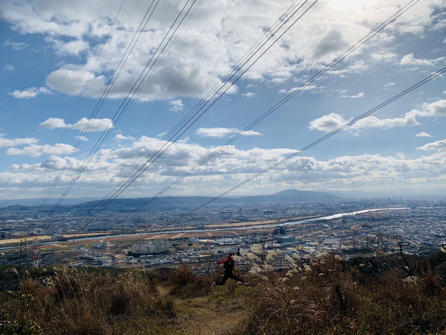 開けた斜面から見下ろす大阪平野と淀川、青空と雲