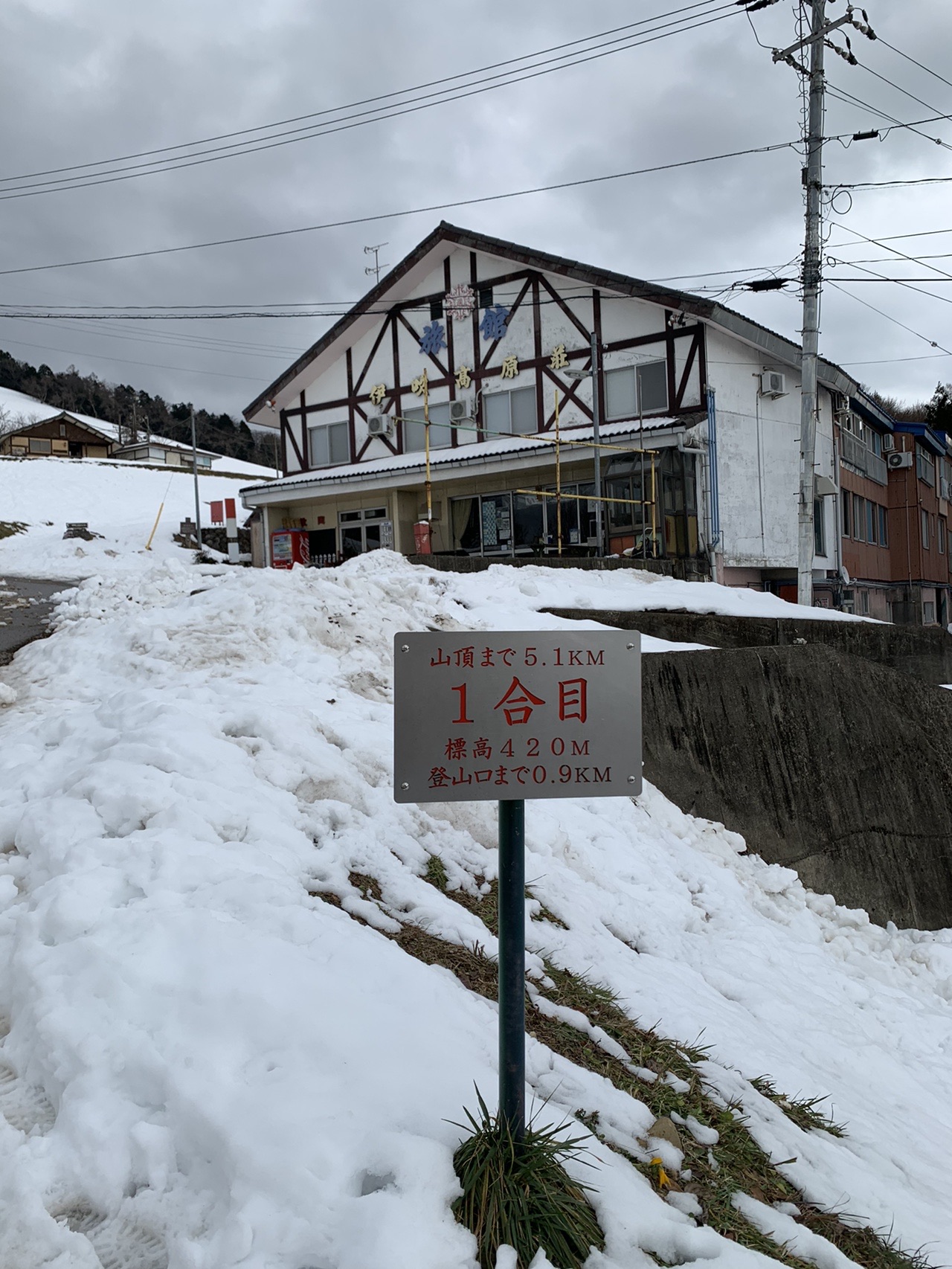雪に埋もれた一合目の建物と標識