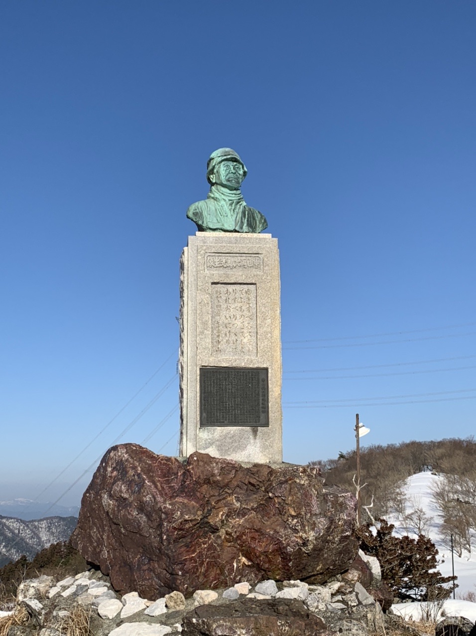 雪の中に立つ人物の銅像
