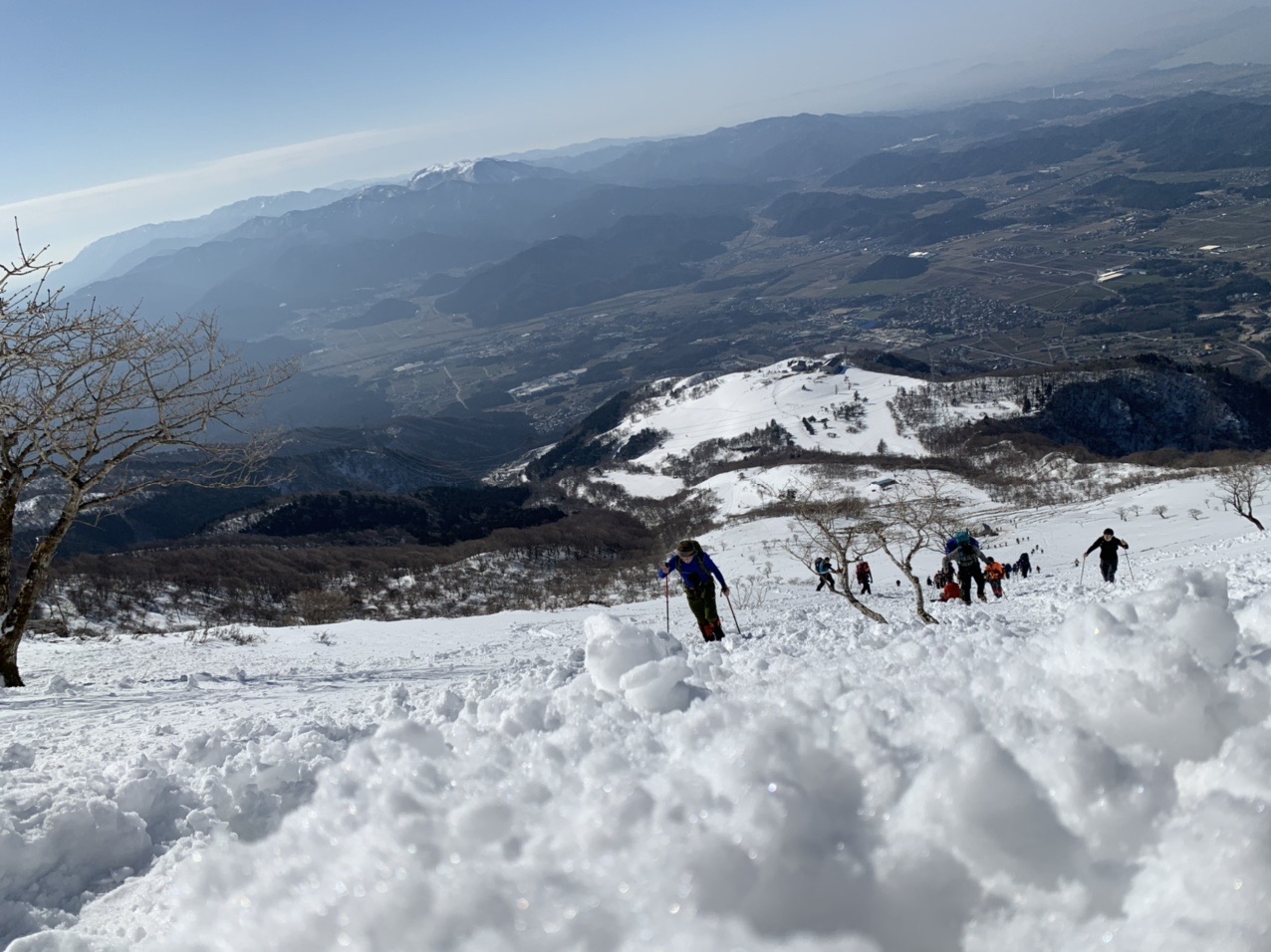 雪の斜面の向こうに広がる琵琶湖と平野