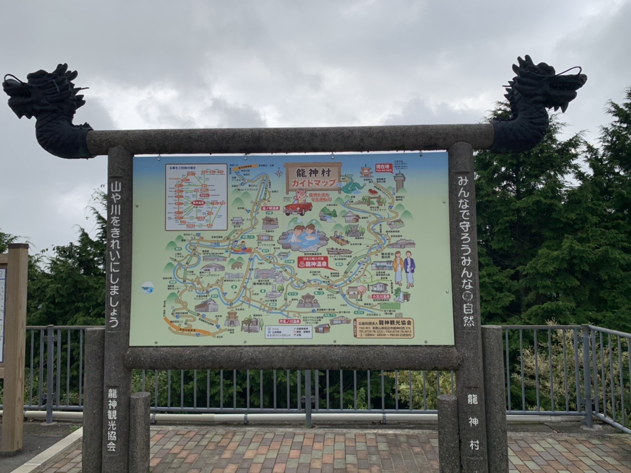 両端に龍の彫刻がついた龍神村の観光案内板