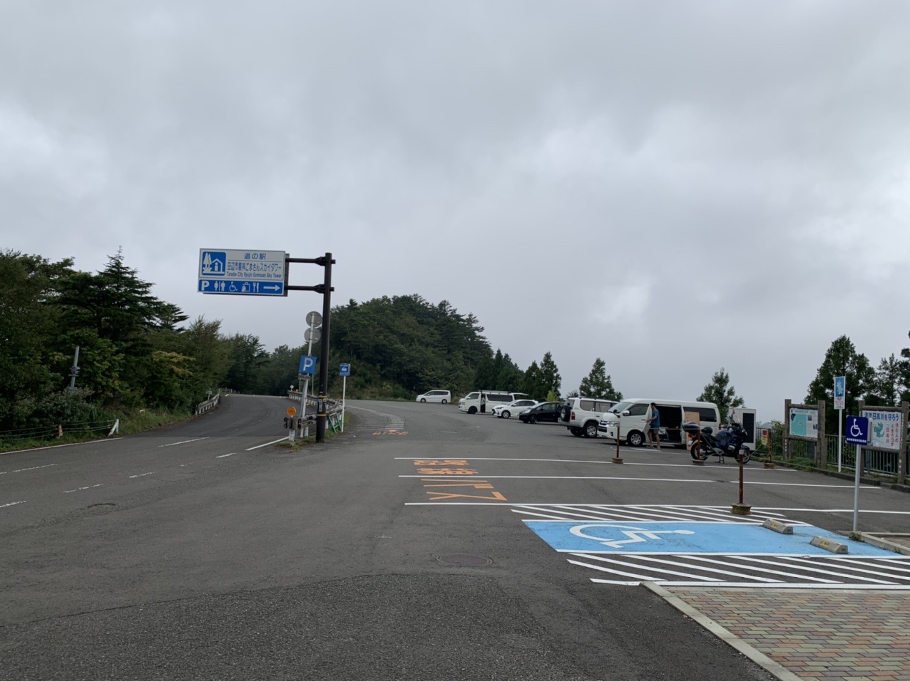 曇り空の下、車が停まった道の駅の駐車場