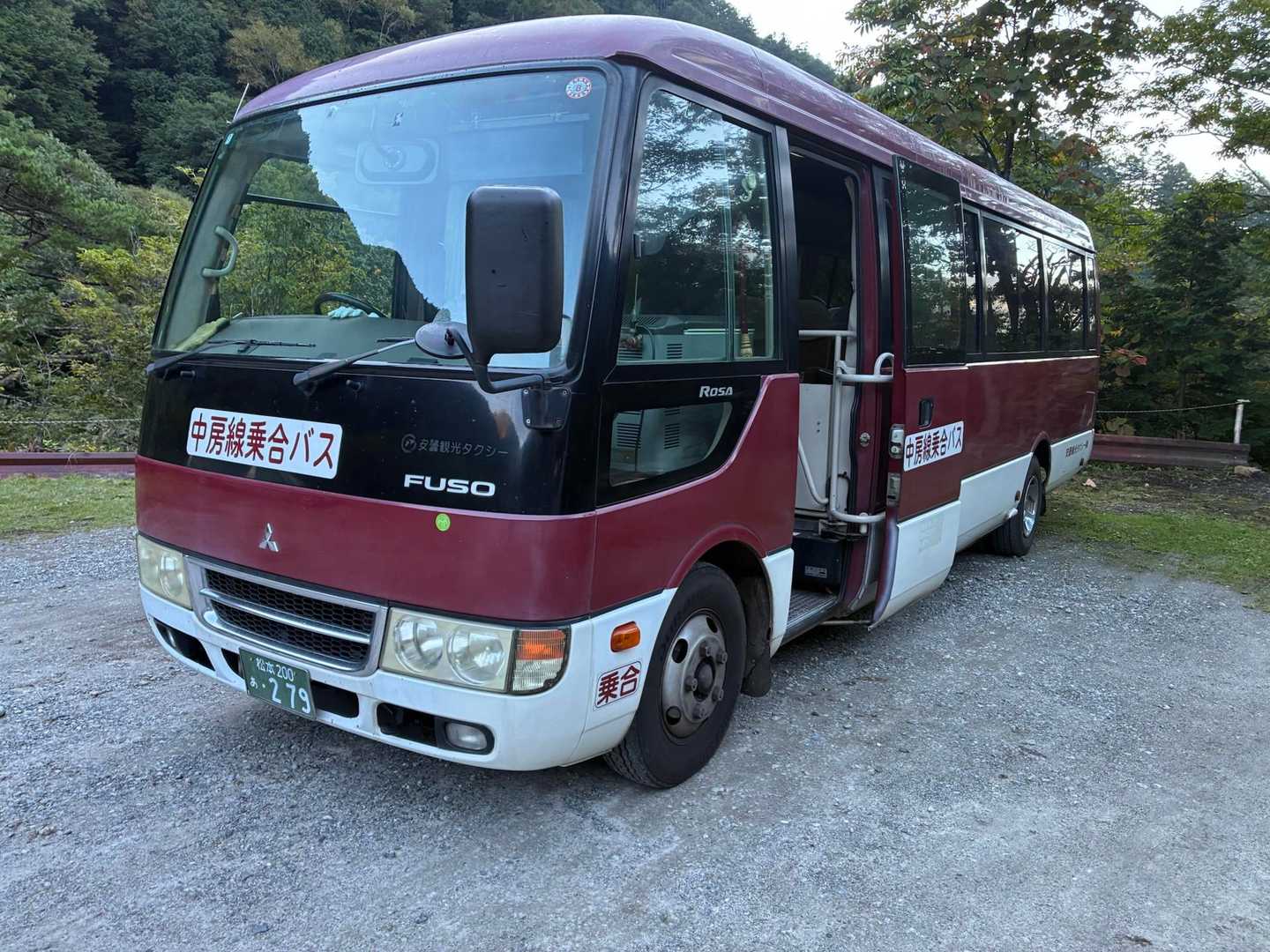 中房線乗合バスと書かれた赤と白の小型バス。安曇観光タクシーの車両
